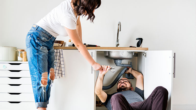 uomo che ripara lavello cucina